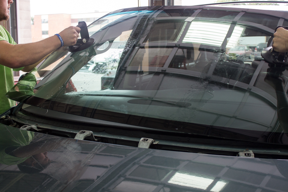 Man working on car glass